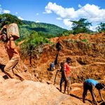 A miner carries ore at Manzou Farm