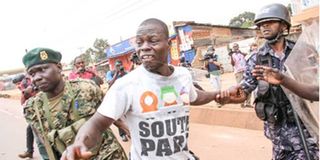 Police arrest an opposition supporter in Kampala.