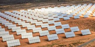 Rows of solar panels in arid landscape.