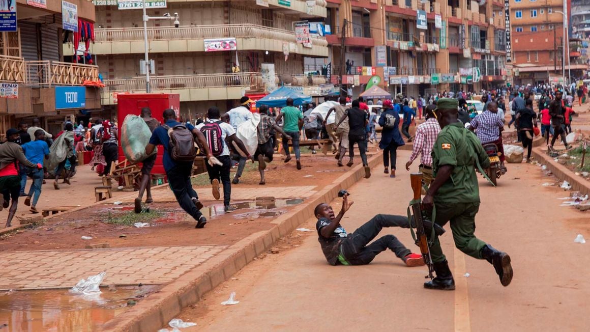 A police officer chases street vendors in Kampala, Uganda 