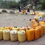 People queue to fetch water. 