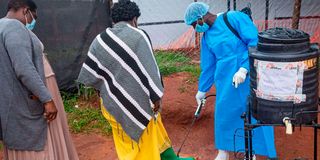 People disinfecting shoes in Mubende, Uganda