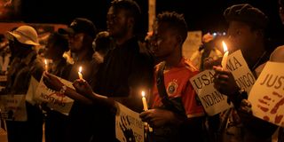 Residents hold candles as they gather in Beni, DR Congo