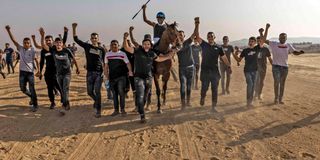 People celebrate with the winning jockey