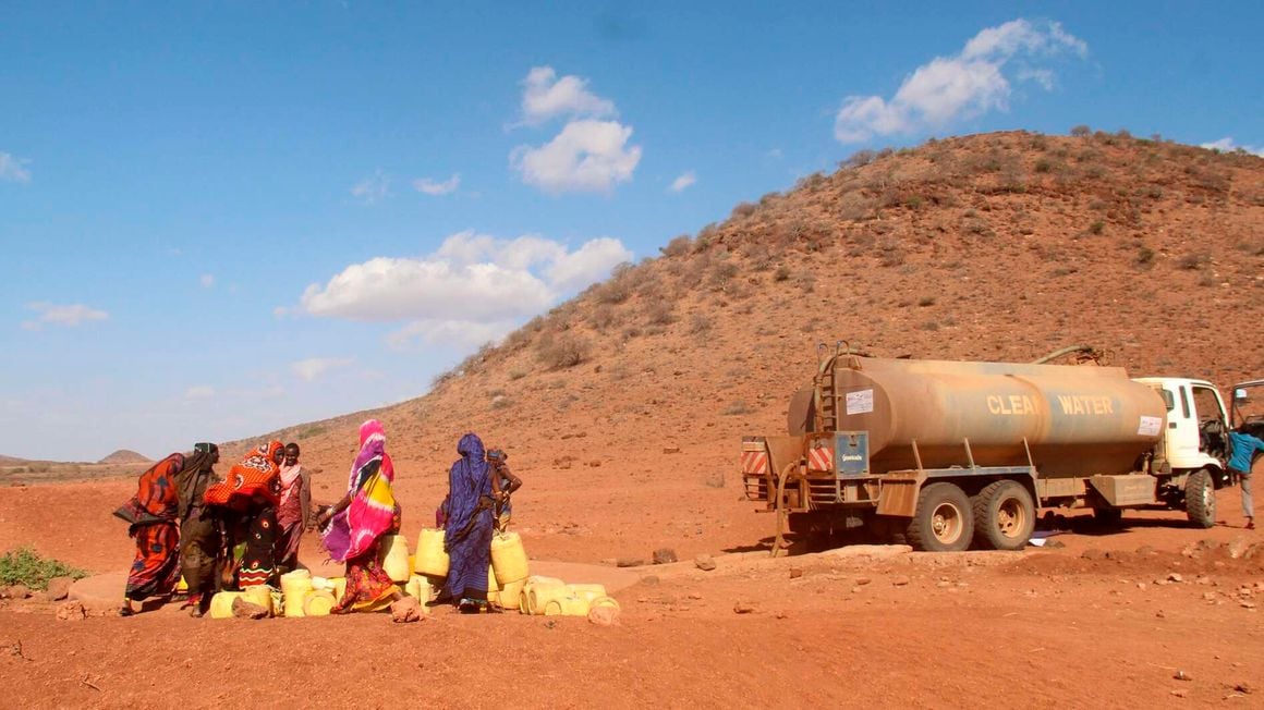 Women wait to fetch water from a bowser 