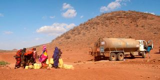 Women wait to fetch water from a bowser 