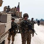 US soldiers stand next to military vehicles