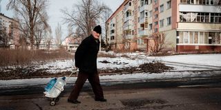 A man carries water containers in Bakhmut