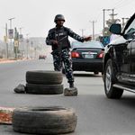 A police officer stops a car at a checkpoint