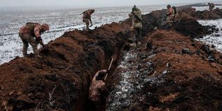 Ukrainian servicemen make a trench near Bakhmut
