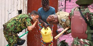 A woman helps police officers with water 