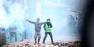 Protestors stand amid tear gas 