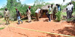 Homicide detectives mark a suspected grave site