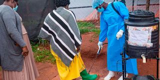 People disinfecting shoes in Mubende, Uganda