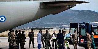 Soldiers carry a Greek national injured in Sudan