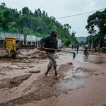 A man removes debris from flooded road in Rwanda