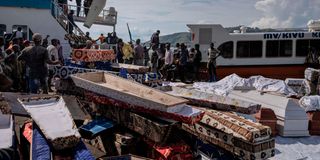 DRC landslides - Volunteers on May 9, 2023 unload coffins