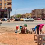 a woman sells drinks in a street in southern Khartoum