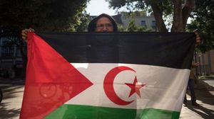 A man poses with a Western Saharan flag.